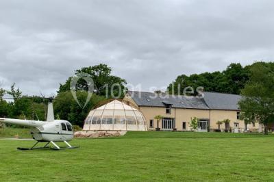 Centre de table floral avec fleurs séchées et pampas, entouré de couverts et cadeaux emballés sur une nappe blanche.