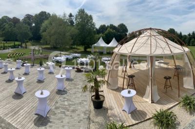 Centre de table floral avec fleurs séchées et pampas, entouré de couverts et cadeaux emballés sur une nappe blanche.