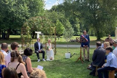Centre de table floral avec fleurs séchées et pampas, entouré de couverts et cadeaux emballés sur une nappe blanche.