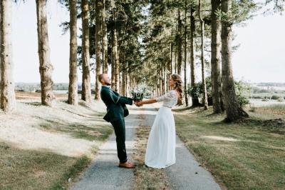 Centre de table floral avec fleurs séchées et pampas, entouré de couverts et cadeaux emballés sur une nappe blanche.