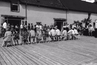 Centre de table floral avec fleurs séchées et pampas, entouré de couverts et cadeaux emballés sur une nappe blanche.