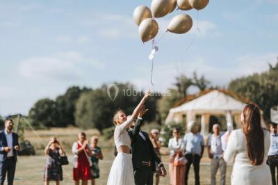 Centre de table floral avec fleurs séchées et pampas, entouré de couverts et cadeaux emballés sur une nappe blanche.