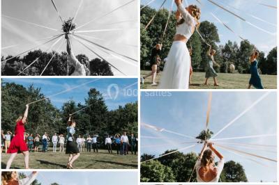 Centre de table floral avec fleurs séchées et pampas, entouré de couverts et cadeaux emballés sur une nappe blanche.