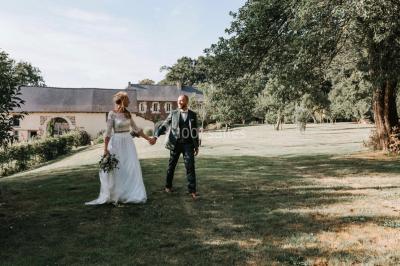 Centre de table floral avec fleurs séchées et pampas, entouré de couverts et cadeaux emballés sur une nappe blanche.