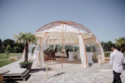 Centre de table floral avec fleurs séchées et pampas, entouré de couverts et cadeaux emballés sur une nappe blanche.