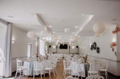 Centre de table floral avec fleurs séchées et pampas, entouré de couverts et cadeaux emballés sur une nappe blanche.