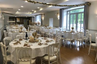 Centre de table floral avec fleurs séchées et pampas, entouré de couverts et cadeaux emballés sur une nappe blanche.