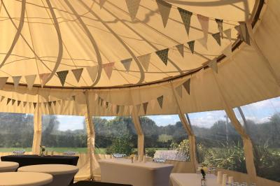 Centre de table floral avec fleurs séchées et pampas, entouré de couverts et cadeaux emballés sur une nappe blanche.