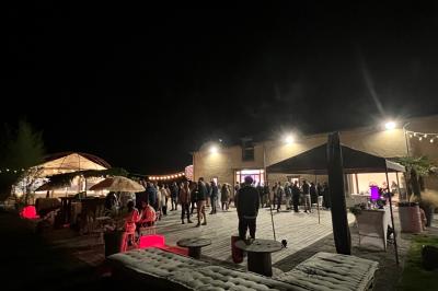 Centre de table floral avec fleurs séchées et pampas, entouré de couverts et cadeaux emballés sur une nappe blanche.