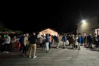 Centre de table floral avec fleurs séchées et pampas, entouré de couverts et cadeaux emballés sur une nappe blanche.