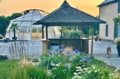 Centre de table floral avec fleurs séchées et pampas, entouré de couverts et cadeaux emballés sur une nappe blanche.