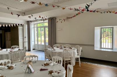Centre de table floral avec fleurs séchées et pampas, entouré de couverts et cadeaux emballés sur une nappe blanche.