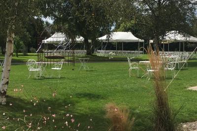 Centre de table floral avec fleurs séchées et pampas, entouré de couverts et cadeaux emballés sur une nappe blanche.