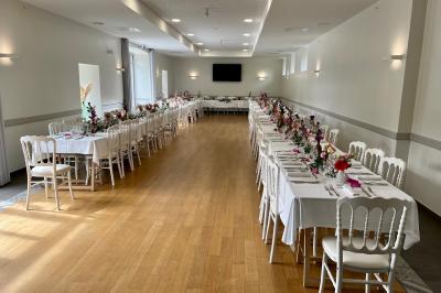 Centre de table floral avec fleurs séchées et pampas, entouré de couverts et cadeaux emballés sur une nappe blanche.