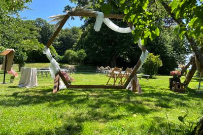 Centre de table floral avec fleurs séchées et pampas, entouré de couverts et cadeaux emballés sur une nappe blanche.