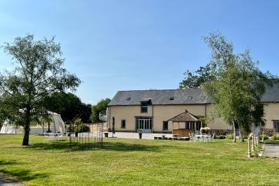 Centre de table floral avec fleurs séchées et pampas, entouré de couverts et cadeaux emballés sur une nappe blanche.