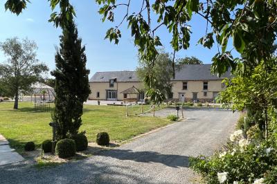 Centre de table floral avec fleurs séchées et pampas, entouré de couverts et cadeaux emballés sur une nappe blanche.