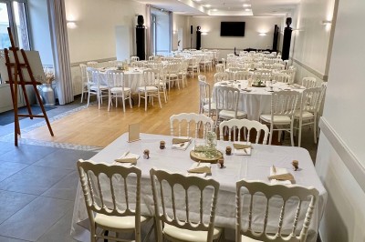 Centre de table floral avec fleurs séchées et pampas, entouré de couverts et cadeaux emballés sur une nappe blanche.
