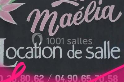 Table de pique-nique en bois sur un sol de gravier, entourée d'arbres dans un cadre naturel.