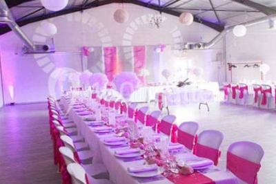 Table de pique-nique en bois sur un sol de gravier, entourée d'arbres dans un cadre naturel.