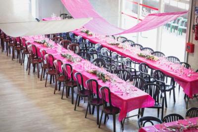 Table de pique-nique en bois sur un sol de gravier, entourée d'arbres dans un cadre naturel.