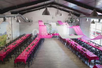 Table de pique-nique en bois sur un sol de gravier, entourée d'arbres dans un cadre naturel.