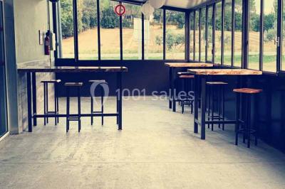 Table de pique-nique en bois sur un sol de gravier, entourée d'arbres dans un cadre naturel.