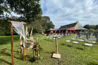 Un couple de mariés ému écoute un joueur de cornemuse, entouré d'invités applaudissant dans une salle lumineuse.