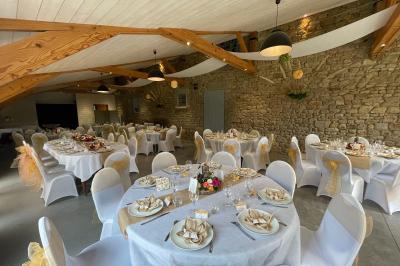Un couple de mariés ému écoute un joueur de cornemuse, entouré d'invités applaudissant dans une salle lumineuse.