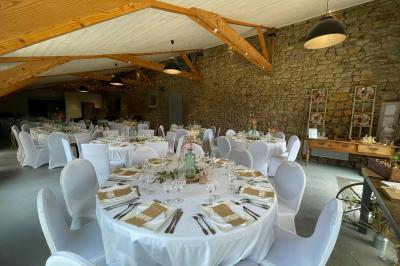 Un couple de mariés ému écoute un joueur de cornemuse, entouré d'invités applaudissant dans une salle lumineuse.