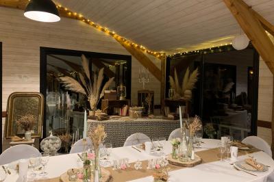 Un couple de mariés ému écoute un joueur de cornemuse, entouré d'invités applaudissant dans une salle lumineuse.