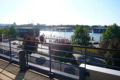 Parking extérieur avec quelques voitures stationnées, entouré de bâtiments modernes et d'arbres alignés.