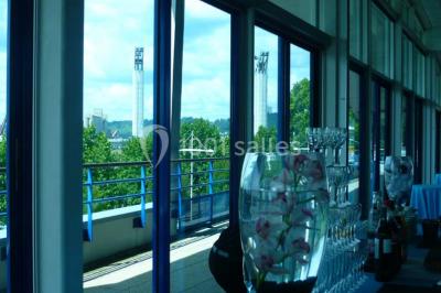 Parking extérieur avec quelques voitures stationnées, entouré de bâtiments modernes et d'arbres alignés.
