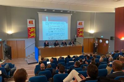 Parking extérieur avec quelques voitures stationnées, entouré de bâtiments modernes et d'arbres alignés.