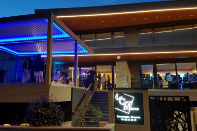 Borne photo interactive sur pied avec écran lumineux, placée à côté d'une mallette noire dans un environnement intérieur.