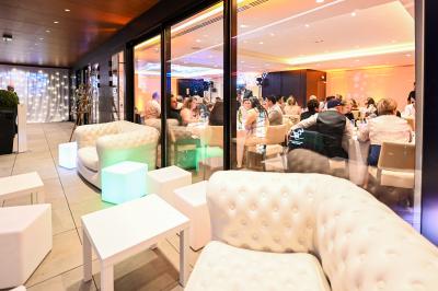 Borne photo interactive sur pied avec écran lumineux, placée à côté d'une mallette noire dans un environnement intérieur.