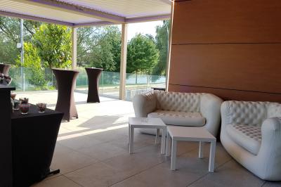 Borne photo interactive sur pied avec écran lumineux, placée à côté d'une mallette noire dans un environnement intérieur.