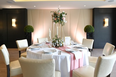 Borne photo interactive sur pied avec écran lumineux, placée à côté d'une mallette noire dans un environnement intérieur.