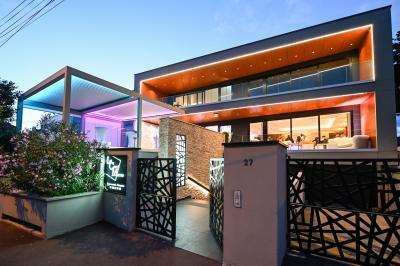 Espace lounge avec canapés blancs, tables basses et vue sur une terrasse arborée avec des tables hautes.