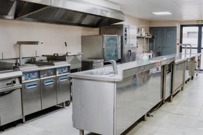 Intérieur d'un véhicule haut de gamme avec volant, tableau de bord et finitions en bois et cuir clair.