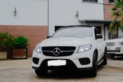Intérieur d'un véhicule haut de gamme avec volant, tableau de bord et finitions en bois et cuir clair.