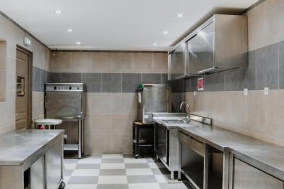 Intérieur d'un véhicule haut de gamme avec volant, tableau de bord et finitions en bois et cuir clair.