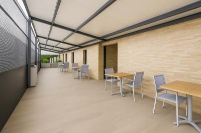 Intérieur d'un véhicule haut de gamme avec volant, tableau de bord et finitions en bois et cuir clair.