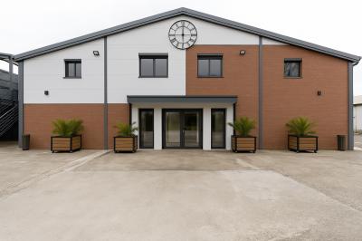 Intérieur d'un véhicule haut de gamme avec volant, tableau de bord et finitions en bois et cuir clair.