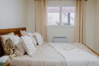 Intérieur d'un véhicule haut de gamme avec volant, tableau de bord et finitions en bois et cuir clair.