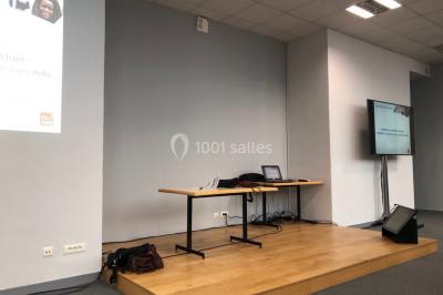 Bâtiment historique avec une chapelle et un terrain de sport au premier plan, sous un ciel partiellement nuageux.