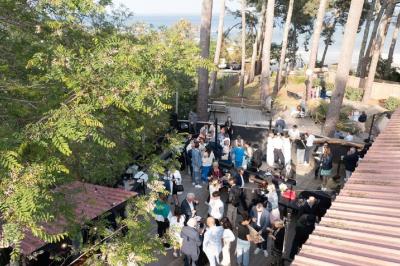 Bar animé avec des lumières colorées, des clients discutant et des paniers suspendus en décoration.