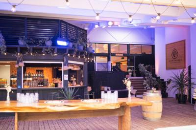 Bar animé avec des lumières colorées, des clients discutant et des paniers suspendus en décoration.