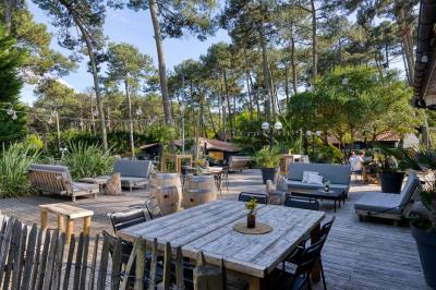 Bar animé avec des lumières colorées, des clients discutant et des paniers suspendus en décoration.