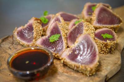 Bar animé avec des lumières colorées, des clients discutant et des paniers suspendus en décoration.
